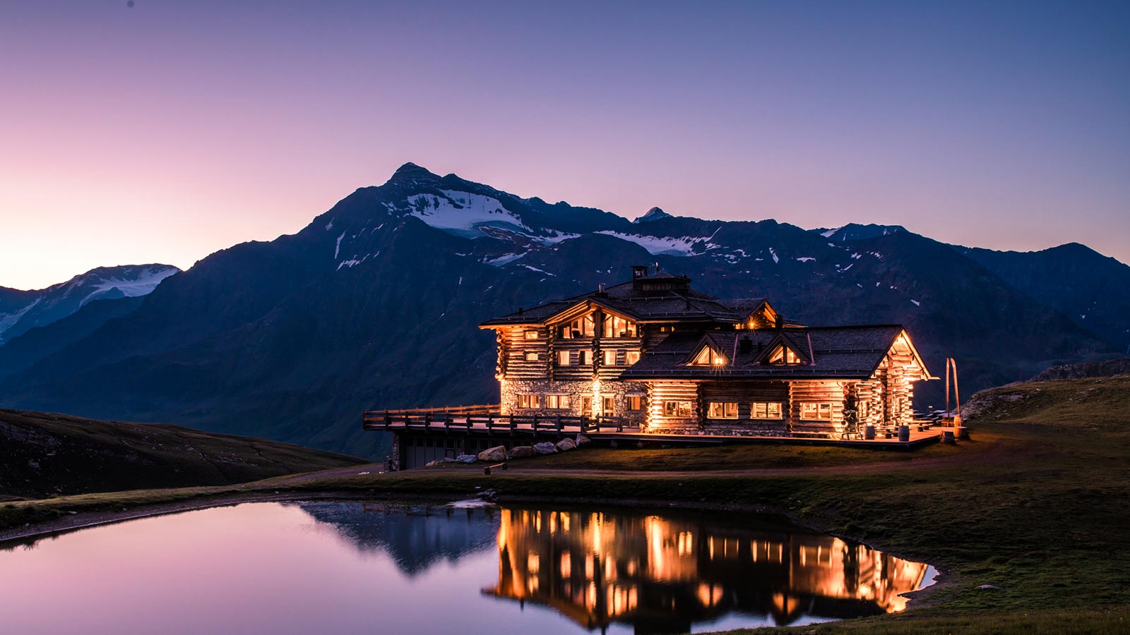 The mountain lodge at night illuminated by lights near the natural park of Stelvio